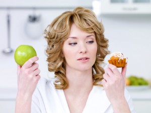 Woman choose between cake and apple